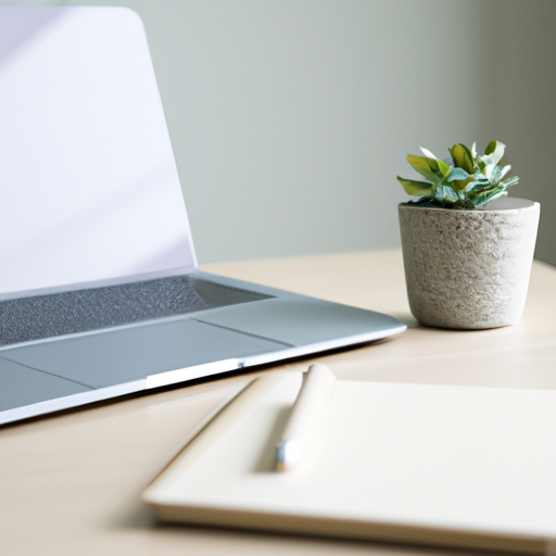 Image of a well-organized workspace with a laptop, notebook, and plant